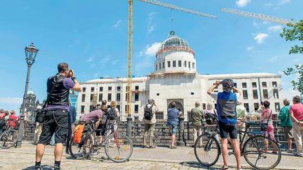 Punktlandung. Am Freitagmittag ließ ein Kran den Richtkranz auf der Kuppel des Humboldtforums nieder. Schaulustige verfolgten das Ereignis von außen – an diesem Wochenende darf dann jeder auf die Baustelle.
