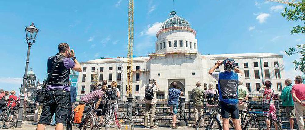 Punktlandung. Am Freitagmittag ließ ein Kran den Richtkranz auf der Kuppel des Humboldtforums nieder. Schaulustige verfolgten das Ereignis von außen – an diesem Wochenende darf dann jeder auf die Baustelle.