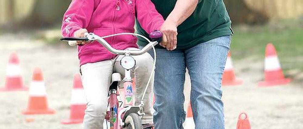 Immer schön in der Spur bleiben. Die Dame in Grün von der Verkehrswacht muss am Anfang noch das Rad festhalten. Später schafft es Emilia aus Serbien, die im Flüchtlingsheim am Lerchensteig wohnt, auch ohne Hilfe.