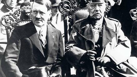 Hitler und Hindenburg. Der neue Reichskanzler (l.) und der 86-jährige Reichspräsident sitzen während der Eröffnungssitzung des neuen Parlaments in der Potsdamer Garnisonkirche nebeneinander. Später geben sie sich die Hand.