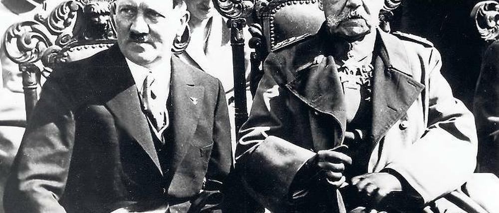 Hitler und Hindenburg. Der neue Reichskanzler (l.) und der 86-jährige Reichspräsident sitzen während der Eröffnungssitzung des neuen Parlaments in der Potsdamer Garnisonkirche nebeneinander. Später geben sie sich die Hand.
