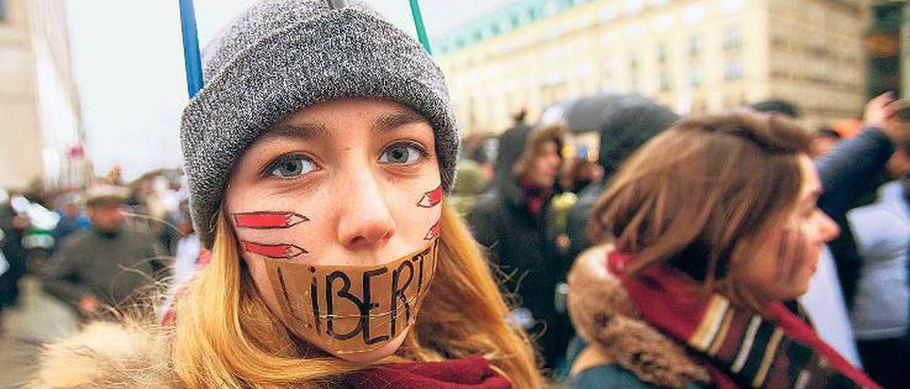 Meinungsfreiheit. Eine junge Frau zeigt am Pariser Platz ihre Sicht.