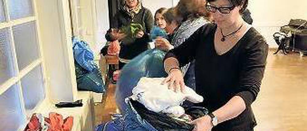 Eingetütet. Beate Apelt sortiert mit anderen Helfern die Kleinderspenden.
