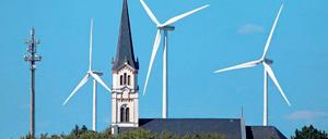 Windräder hinter der Kirche von Ragewitz (Sachsen). Die Windräder der neuen Generation sind allerdings viermal so hoch wie mancher Kirchturm.