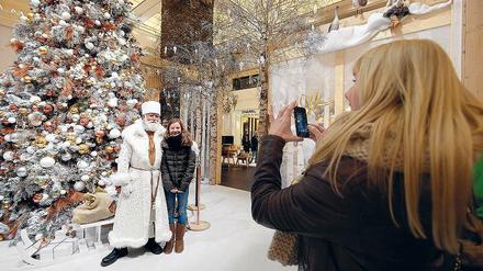Souvenirs, Souvenirs. Viele Besucher ließen sich am gestrigen Sonntag im KaDeWe mit einem Weihnachtsmann fotografieren. Der trägt Weiß – getreu dem Kaufhaus-Motto, das allen Kunden eine friedliche weiße Weihnacht wünscht. Friedlich war zwar am Vortag nichts, doch an den Raubüberfall vom Sonnabend erinnert nichts mehr.