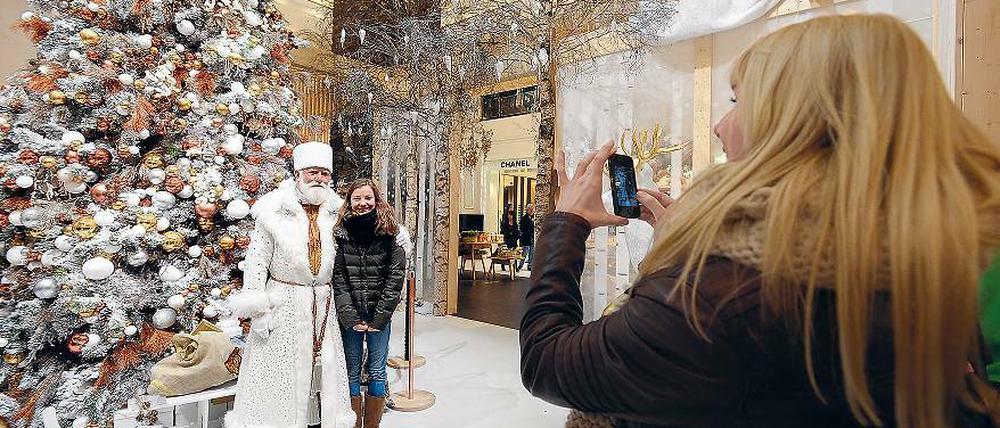Souvenirs, Souvenirs. Viele Besucher ließen sich am gestrigen Sonntag im KaDeWe mit einem Weihnachtsmann fotografieren. Der trägt Weiß – getreu dem Kaufhaus-Motto, das allen Kunden eine friedliche weiße Weihnacht wünscht. Friedlich war zwar am Vortag nichts, doch an den Raubüberfall vom Sonnabend erinnert nichts mehr.