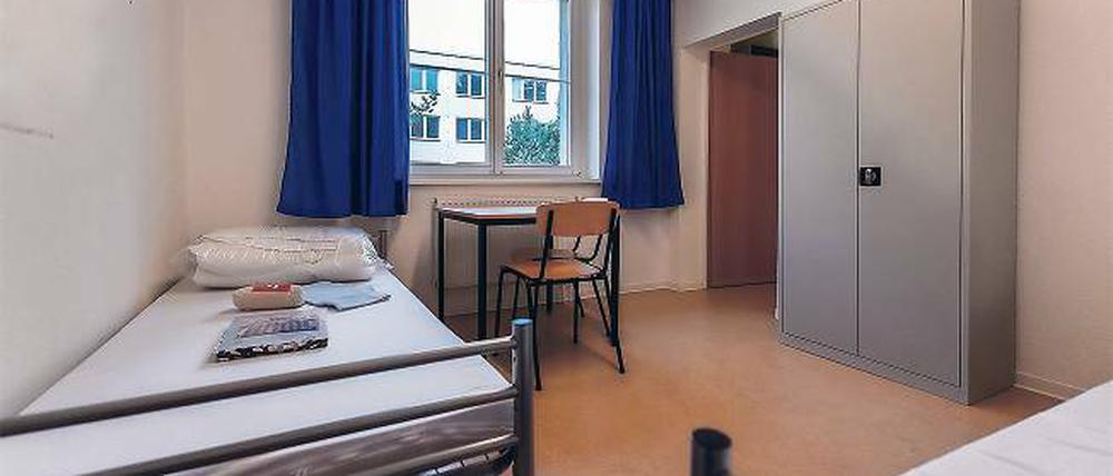 Einfache Ausstattung. Zwei Betten, ein Tisch mit Stühlen und ein Schrank.