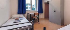 Einfache Ausstattung. Zwei Betten, ein Tisch mit Stühlen und ein Schrank.