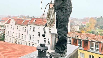 Hoch oben ist die Luft am besten. Schornsteinfeger Volker Hey, dessen Revier Bornstedt, Bornim, Grube, Nedlitz sowie einen Teil von Eiche umfasst, bei der seltenen Arbeit auf dem Dach.