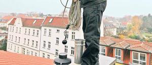 Hoch oben ist die Luft am besten. Schornsteinfeger Volker Hey, dessen Revier Bornstedt, Bornim, Grube, Nedlitz sowie einen Teil von Eiche umfasst, bei der seltenen Arbeit auf dem Dach.