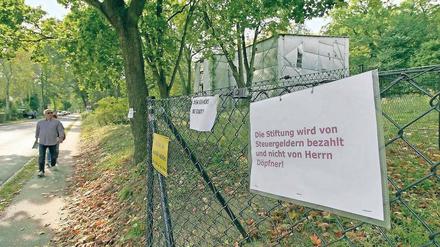 Streit unter Nachbarn. Mit Schildern wird gegen den Bauzaun protestiert, den Mathias Döpfner im Auftrag der Schlösserstiftung um das Grundstück der Gartenanlage der Villa Henckel und der Villa Schlieffen errichten ließ.