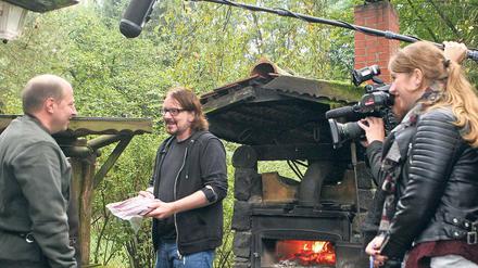 Filetübergabe, die erste. Uwe Große- Wortmann (M.) hat bei Volker Paulus (l.) von der Märkischen Wildschweinbäckerei Fleisch bestellt. Immer dabei: das Kamerateam.