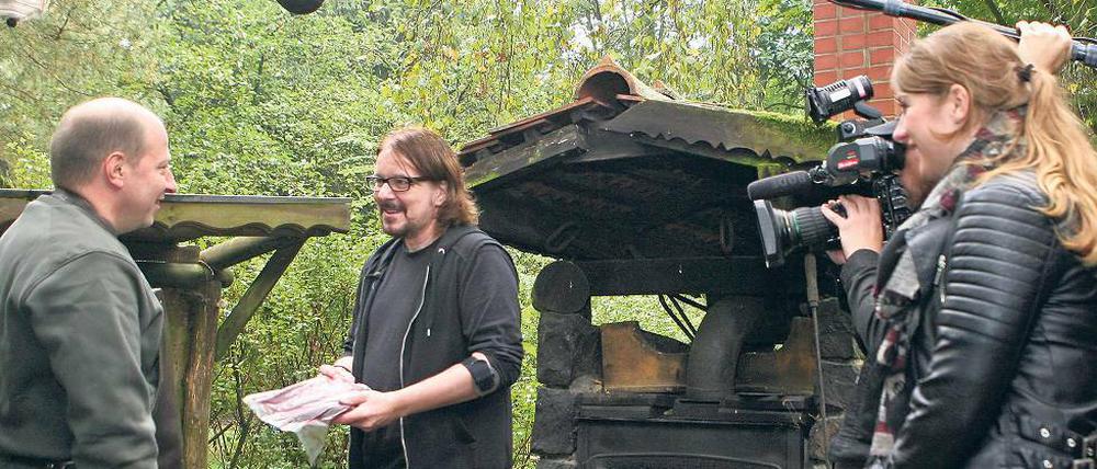 Filetübergabe, die erste. Uwe Große- Wortmann (M.) hat bei Volker Paulus (l.) von der Märkischen Wildschweinbäckerei Fleisch bestellt. Immer dabei: das Kamerateam.