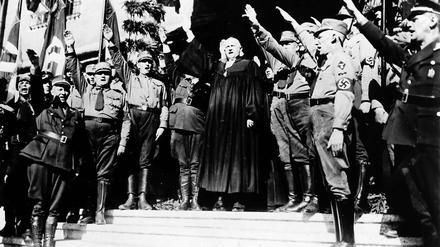 Pfarrer mit Hitlergruß. Die Deutschen Christen, hier Landesbischof Ludwig Müller bei der „Nationalsynode“ 1933 in Wittenberg, traten für eine gleichgeschaltete Reichskirche ein. Die Bekennende Kirche hingegen wehrte sich gegen den Einfluss des Naziregimes.
