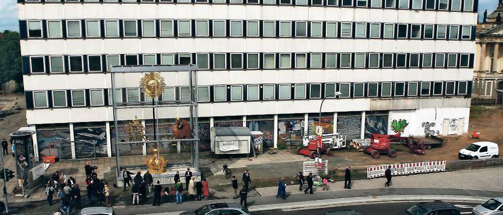 Der Ort. Am Rechenzentrum in der Breiten Straße steht – gut gesichert – die Wetterfahne für den geplanten Turm der Garnisonkirche (l.). Das DDR-Gebäude muss Ende 2017 unter anderem für den Wiederaufbau der Garnisonkirche weichen. Diskutiert wird, wo das Glasmosaik „Mensch bezwingt Kosmos“ neu aufgehängt wird.