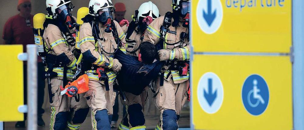Alles simuliert. Feuerwehrmänner transportieren einen Verletzten ab.