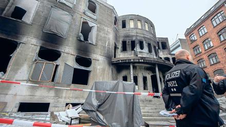 Ursache unbekannt. Ein Polizeibeamter steht vor dem nach einem Feuer am 11. August beschädigten Neubau der Meylana-Moschee in Kreuzberg. Nach neuesten Erkenntnissen kann Brandstiftung nicht ausgeschlossen werden.