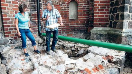 Geheimnis unter der Kirche. Der Feldsteinring im Vordergrund könnte das Fundament eines Burgturms gewesen sein – oder eines Brunnens. Archäologe Michael Böhm und Annett Pratsch von der Unteren Denkmalschutzbehörde des Landkreises untersuchten die Fundstelle.