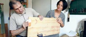 Tischlert gern. Peter Bergmann, Bewohner des Tageszentrums für psychisch Kranke, beim Schleifen von Regalbrettern. Rechts: Leiterin Anne Bresgott.