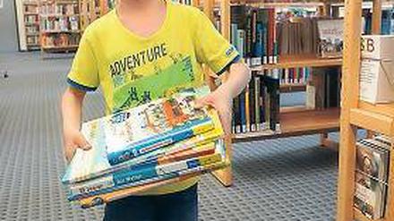 Her mit dem Lesestoff. In den Ferien ist die Bibliothek bei Kindern sehr beliebt.