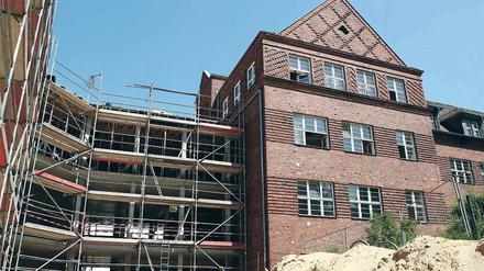 Mit Dach. Der dreistöckige Verbinder und der historische Altbau.