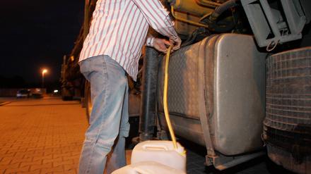 Diesel wird aus einem LKW-Tank abgezapft.