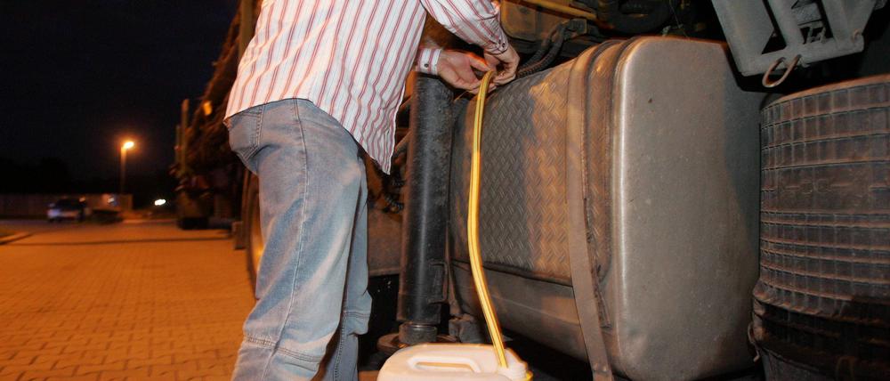 Diesel wird aus einem LKW-Tank abgezapft.