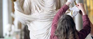 Zurück in der „Schönsten der Welt“. Die antike Figur einer Betenden mit dem Porträtkopf der Kaiserin Sabina wird in der historischen Bildergalerie des Schlosses Sanssouci von Restauratoren in Augenschein genommen.