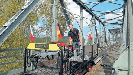 Los geht’s. Immer am Wochenende startet die Draisinenbahn ihren Pendelbetrieb von Neu-Rüdnitz über die Oder. Allerdings geht die Fahrt nur bis zur Brückenmitte – dort stoppt ein Prellbock das Schienenfahrzeug.