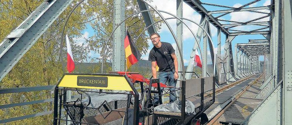 Los geht’s. Immer am Wochenende startet die Draisinenbahn ihren Pendelbetrieb von Neu-Rüdnitz über die Oder. Allerdings geht die Fahrt nur bis zur Brückenmitte – dort stoppt ein Prellbock das Schienenfahrzeug.