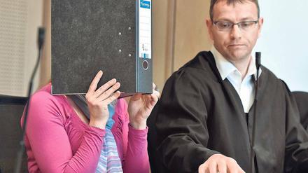 Prozessauftakt. Die Angeklagte Maika M. verdeckt ihr Gesicht hinter einem Aktenordner – neben ihr Anwalt Stefan Böhme am Dienstag im Landgericht in Frankfurt (Oder). Die 22-jährige Mutter soll den kleinen neugeborenen Jungen erstochen haben.