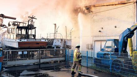 Zufall? Berliner Feuerwehrleute bekämpfen den Brand am frühen Morgen.
