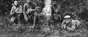 Während des Krieges wurden in deutschen Zeitungen und in Filmen so gut wie überhaupt keine Bilder von Kampfhandlungen gezeigt. Allenfalls waren gestellte Bilder zu sehen, oder Filmaufnahmen. Verletzte oder gar Tote waren nicht zu sehen, so dass die Vorstellung vom Krieg idealisiert blieb. - hier ein Truppführer mit einem Fernglas in der Hand kauert mit seinen Soldaten 1915 an einem Waldrand an der Westfront.