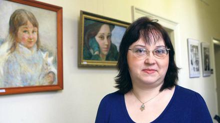 Künstlerin mit Selbstporträt. Inessa Rozenstein vor einem ihrer Bilder.