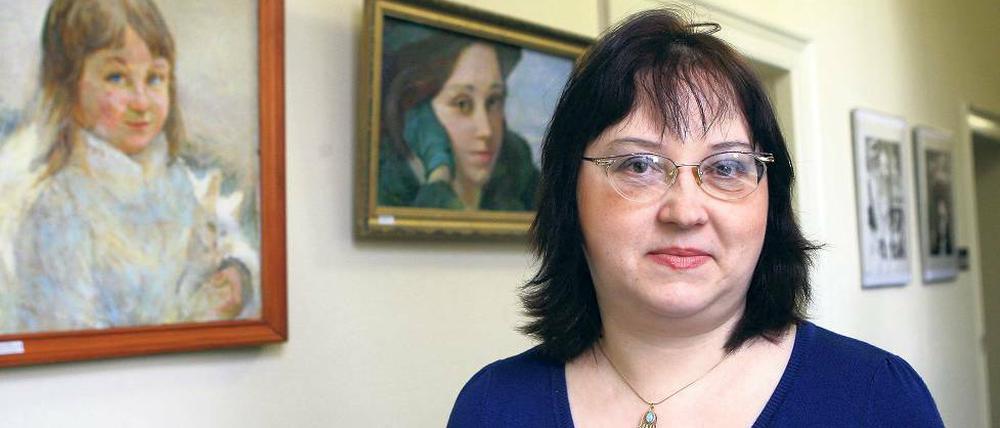 Künstlerin mit Selbstporträt. Inessa Rozenstein vor einem ihrer Bilder.