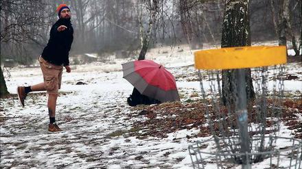 Mit Frisbee und Regenschirm. Torsten Baus, Deutscher Vize-Meister von 2012, schützt seine Flugscheiben vor der direkten Nässe.
