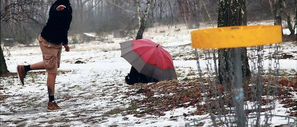 Mit Frisbee und Regenschirm. Torsten Baus, Deutscher Vize-Meister von 2012, schützt seine Flugscheiben vor der direkten Nässe.