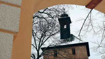 Blick durchs Gutstor auf die Kirche. In nächster Nachbarschaft ist der Neubau geplant.