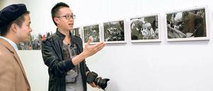 Hingeschaut. Rapeepat Boonmongkolwat (re.) erklärt seinen Bilderzyklus