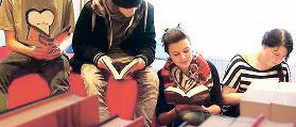 Vertieft. Die Neuntklässler Christoph und Angelique in der neuen Bibliothek.