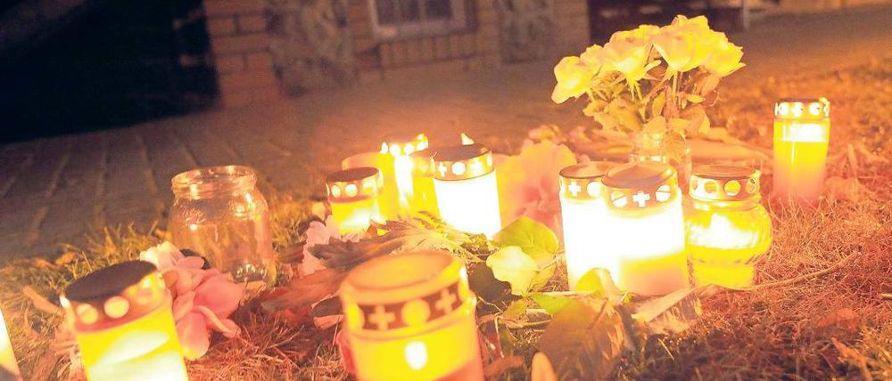 Trauer. Kerzen und Blumen vor dem Haus der ermordeten Seniorin.