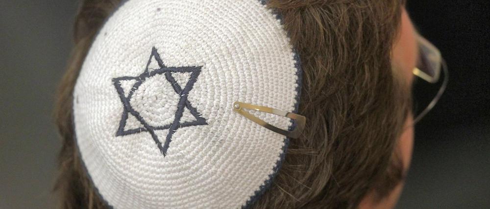 Ein Besucher einer Synagoge mit der Kopfbedeckung Kippa.