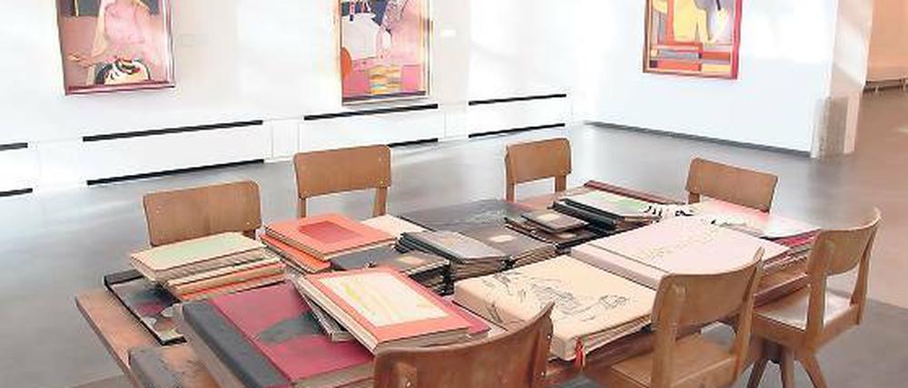 Kunst als Erarbeitungsprozess. Ein Tisch in der Ausstellung „Bruchstücke“ mit Folianten, Skizzensammlungen und Unikaten, die Mike Bruchner als Buch-Illustrator gestaltet hat.