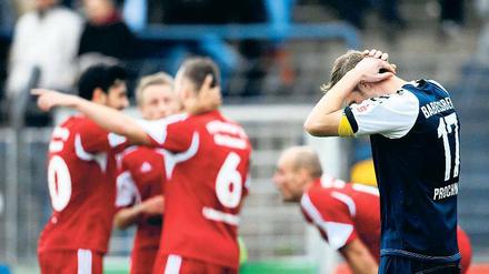 Eindeutige Bildersprache: Während sich die Spieler von Wacker Nordhausen über ihren ersten Auswärtssieg freuen, kann Nulldrei-Kapitän Julian Prochnow seine Enttäuschung nach der 2:3-Niederlage nicht verbergen.