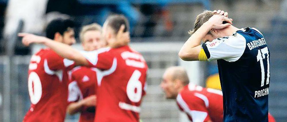 Eindeutige Bildersprache: Während sich die Spieler von Wacker Nordhausen über ihren ersten Auswärtssieg freuen, kann Nulldrei-Kapitän Julian Prochnow seine Enttäuschung nach der 2:3-Niederlage nicht verbergen.