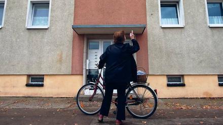 Erneut totes Baby entdeckt. Eine Frau steht vor dem Mehrfamilienhaus im Oderbruchort Golzow, wo zuvor ein totes Baby gefunden wurde. Die 21 Jahre alte Mutter wurde festgenommen.