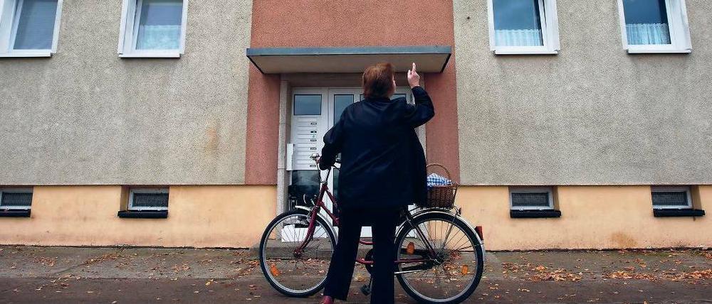 Erneut totes Baby entdeckt. Eine Frau steht vor dem Mehrfamilienhaus im Oderbruchort Golzow, wo zuvor ein totes Baby gefunden wurde. Die 21 Jahre alte Mutter wurde festgenommen.