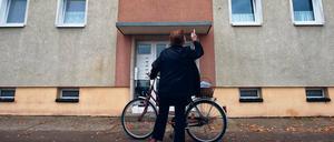 Erneut totes Baby entdeckt. Eine Frau steht vor dem Mehrfamilienhaus im Oderbruchort Golzow, wo zuvor ein totes Baby gefunden wurde. Die 21 Jahre alte Mutter wurde festgenommen.