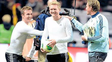 Souvenir einer erfolgreichen Dienstreise. André Schürrle hat sich den Ball geschnappt, Götze (l.) und Adler freuen sich mit ihm.