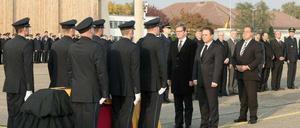 Bundesaußenminister Guido Westerwelle (FDP), Bundesinnenminister Hans-Peter Friedrich (CSU) und der Präsident der Bundespolizei Dieter Romann (l-r) verneigen sich vor dem Sarg mit den sterblichen Überresten des im Jemen getöteten Bundespolizisten.